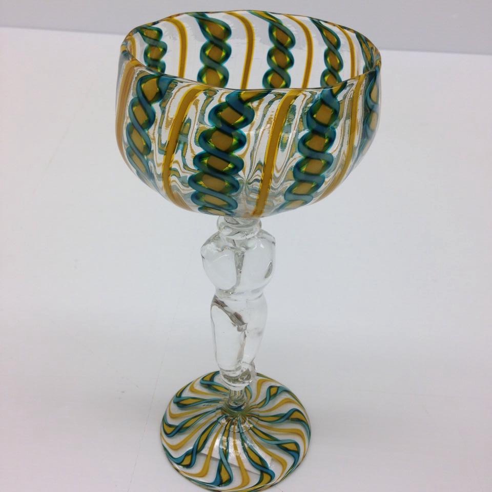 Transparent glass goblet with dark green and dark yellow patterns and clear glass torso as stem
