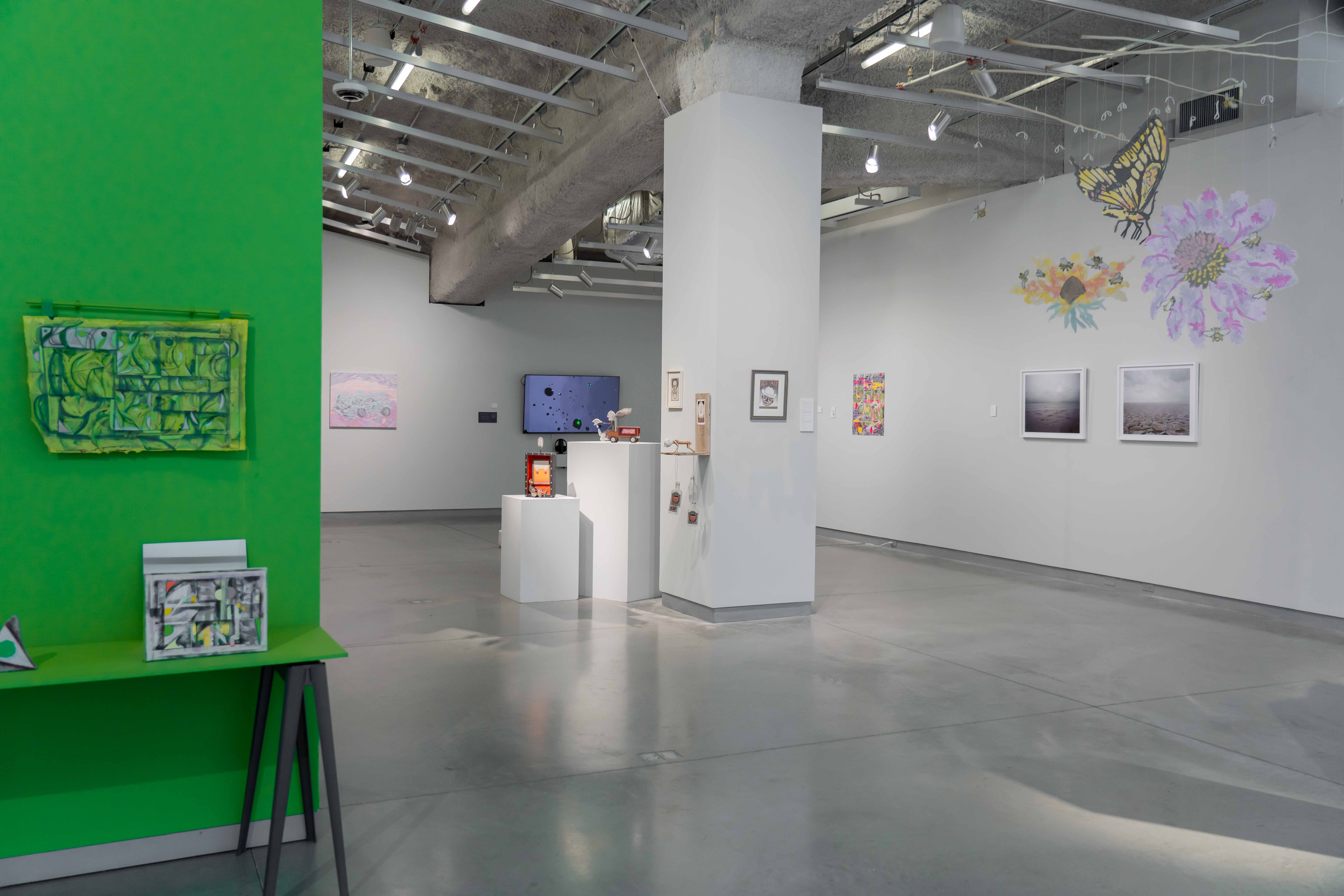 Contemporary art gallery with abstract paintings, wall murals, and sculptures on display.