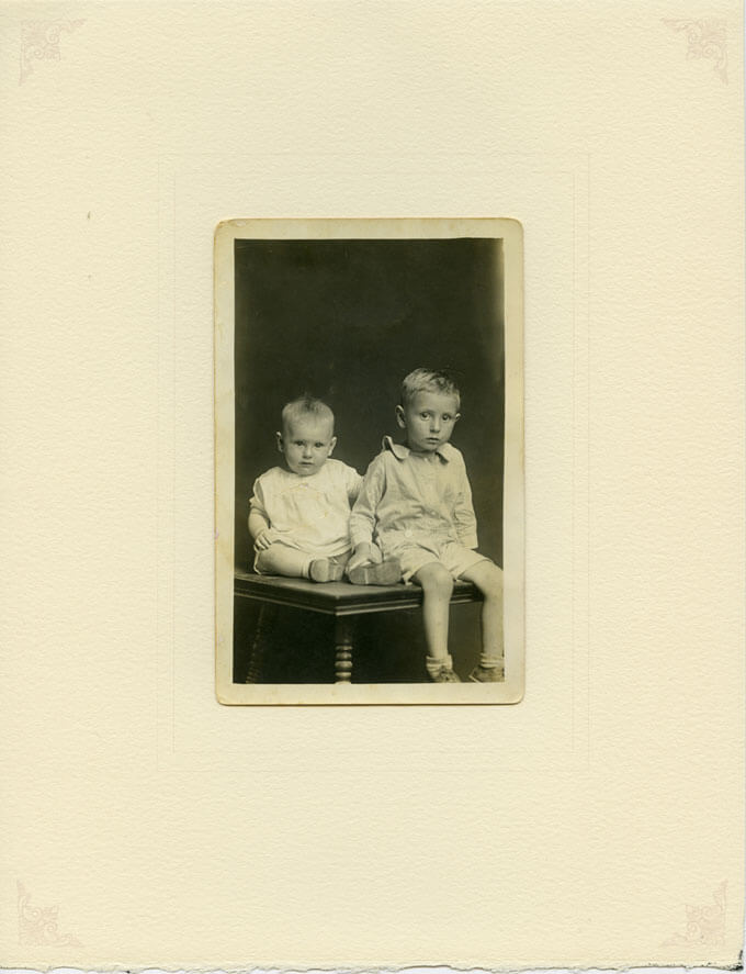 Two brothers seated on table