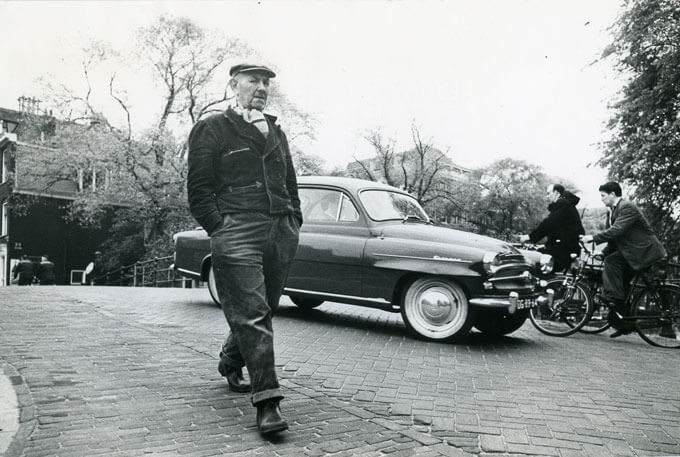 Man walks in front of car on bridge over Herengracht canal (Amsterdam, Holland)