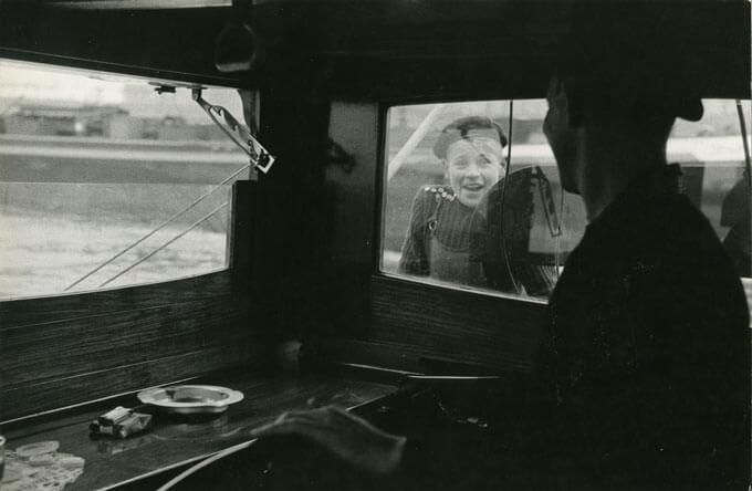 Bram receives instructions from the skipper through the window of steering cabin, Amsterdam, Holland, 1958