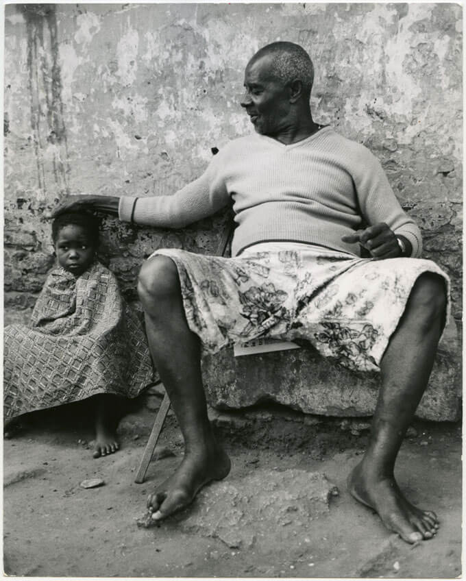 Grandfather rests his hand on his grandson's head.
