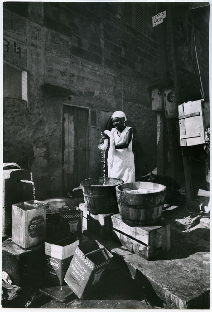 Woman doing laundry in two wooden basins, Rio de Janeiro, Brazil