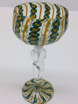 Transparent glass goblet with dark green and dark yellow patterns and clear glass torso as stem