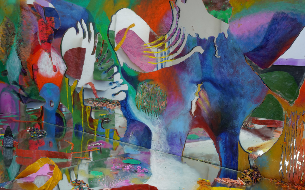 Abstract film still with a mirrored surface reflecting vibrant colors, layered shapes, and textured surfaces.